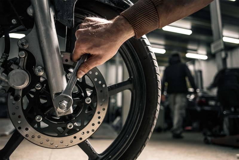 Mécanicien moto expérimenté en pleine révision minutieuse.